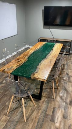 a table made out of wood with chairs around it and a flat screen tv on the wall