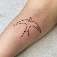 a tattoo on the leg of a person with a bird in it's wings