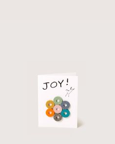 a greeting card with donuts on it and the words joy written in black ink