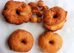 four doughnuts are arranged on a white paper towel