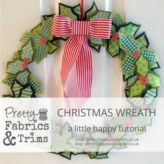 a christmas wreath made out of paper and ribbon hanging on a door with the words pretty fabrics & trims