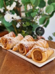 pastries on a white plate with flowers in the background