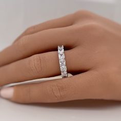 a woman's hand with a diamond ring on her left hand, showing the side view