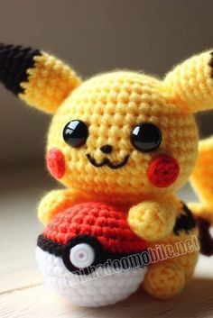 a small crocheted pikachu holding a golf ball