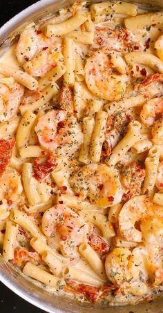 a pan filled with pasta covered in shrimp and sauce