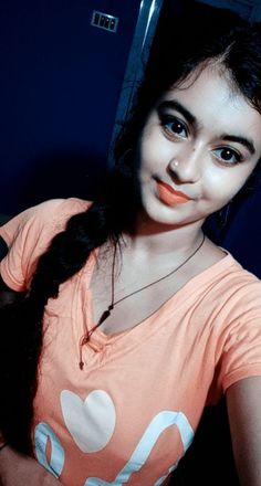 a girl with long black hair wearing an orange shirt