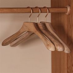 three wooden clothes hangers hanging on a wall