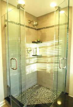 a walk in shower sitting next to a tiled floor and wall with two lights on it