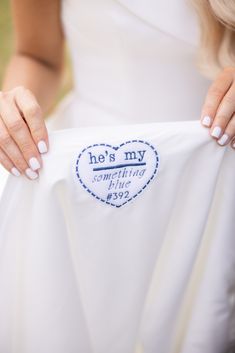 a woman is holding up a white shirt with the words he's my girlfriend on it