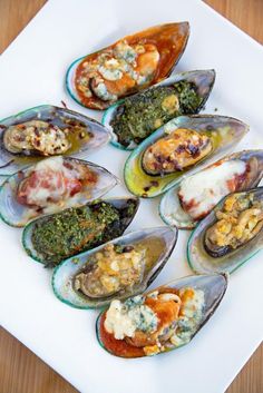 a white plate topped with mussels covered in sauce