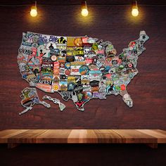 a wooden table topped with a map of the united states covered in stickers