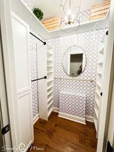 a bathroom with white shelving and wooden flooring next to a mirror on the wall