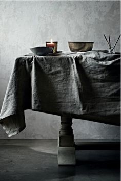 a table with a cloth draped over it and two bowls on top of the table