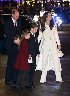 the couple and their children are walking down the street