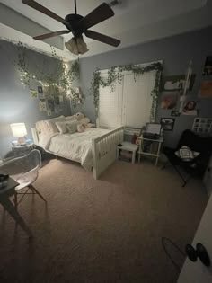 a bedroom with a bed, desk and ceiling fan in the middle of the room