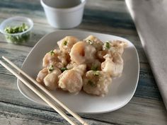 a white plate topped with dumplings next to chopsticks