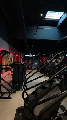 there are many treadmills in the gym with red lights on each one side