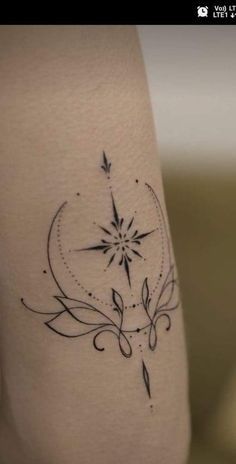 a tattoo on the leg of a woman with a star and swirls around it