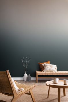 a living room with two chairs and a coffee table in front of a blue wall