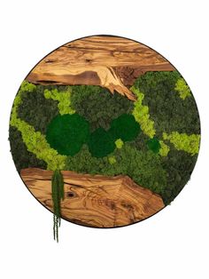 a round wooden table topped with green plants and trees on top of wood planks