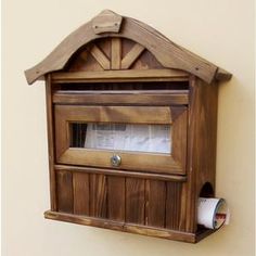 a wooden mailbox mounted to the side of a wall