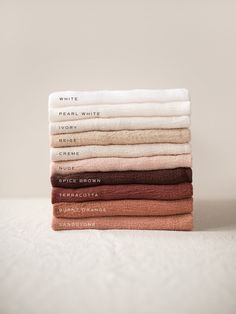 six folded towels stacked on top of each other in different colors and sizes, with the words'dear white'printed on them