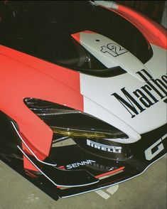 the front end of a race car painted in red, white and black