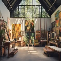 an artist's studio with lots of paintings on the walls