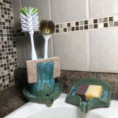 two toothbrushes and soap in a bathroom sink