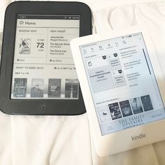 two kindle devices sitting on top of a white bed next to each other,