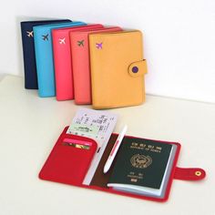 three passport cases and a passport holder on a table