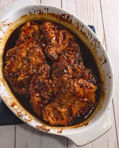 the meat is cooked and ready to be served in the dish on the wooden table