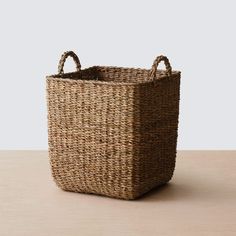 a woven basket with handles sitting on a table