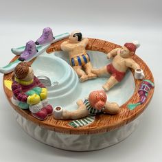 two figurines are sitting in a bowl