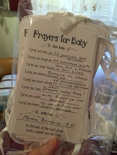 a person holding up a prayer card in a plastic bag with the words f prays for baby written on it