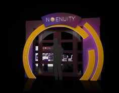 a man standing in front of a purple and yellow sign that says no nuitty