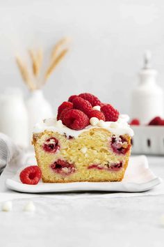 a close up of a muffin on a plate with raspberries