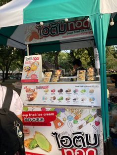 a man standing next to a kiosk with food on it's side