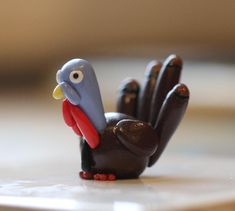 a small toy turkey sitting on top of a table