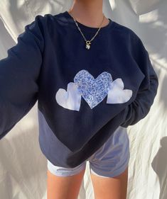 a woman wearing shorts and a sweatshirt with hearts on it