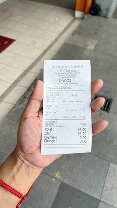 a person holding up a receipt in their hand