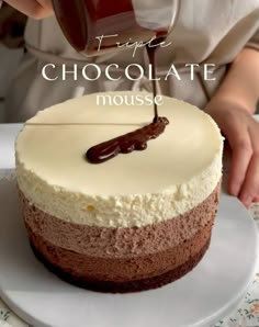 a person pouring chocolate into a cake on a plate with the words triple chocolate mousse