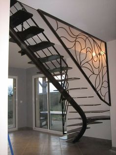 a spiral staircase in an empty house with glass doors and railings on the side