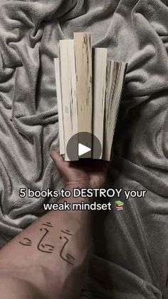 someone is holding an open book in their hand with the text 5 books to destroy your weak mindset