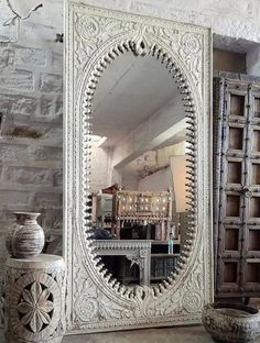 an ornate white mirror sitting on top of a table