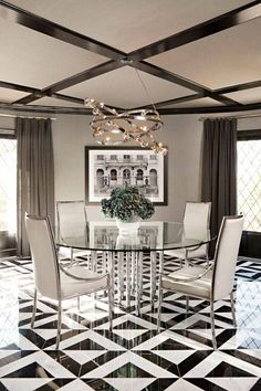 a dining room with black and white checkered flooring, chandelier and glass table