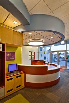 an office cubicle with a laptop computer on the desk and shelves in front of it