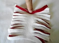 someone is making something out of white material with red strips on the bottom and top