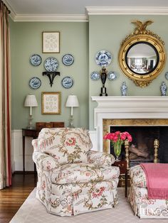 a living room filled with furniture and a fire place under a mirror on the wall