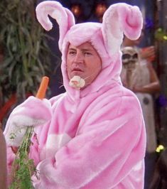 a man in a pink bunny costume holding a carrot